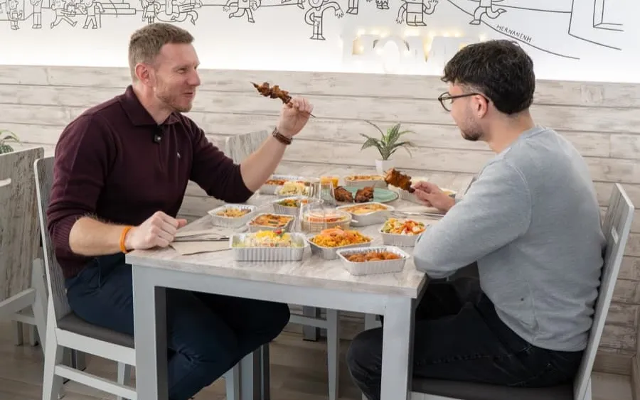 Dos clients dinant a Gaudeix amb la taula plena de plats casolans per compartir